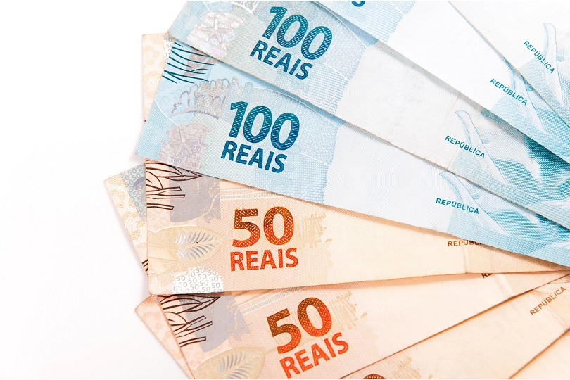 Notas de 50 e cem reais sob fundo branco.
