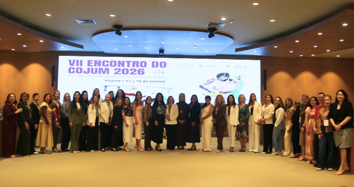 Foto posada, em pé, dos(as) participantes do evento.