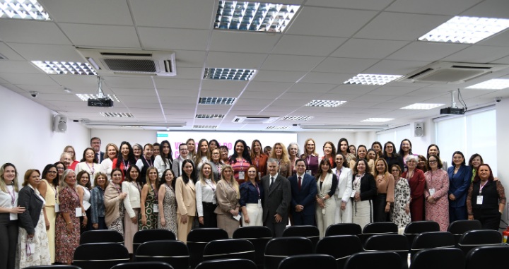 Foto posada, em pé, dos(as) participantes do evento.