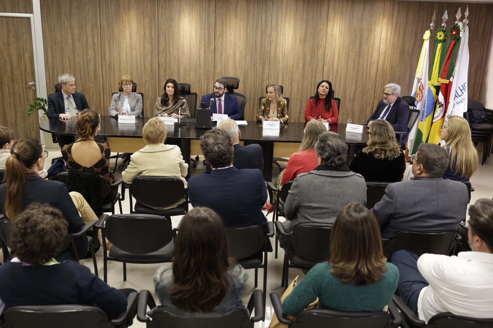 foto geral do salão nobre. público aparece de costas em primeiro plano, com a mesa oficial ao fundo.