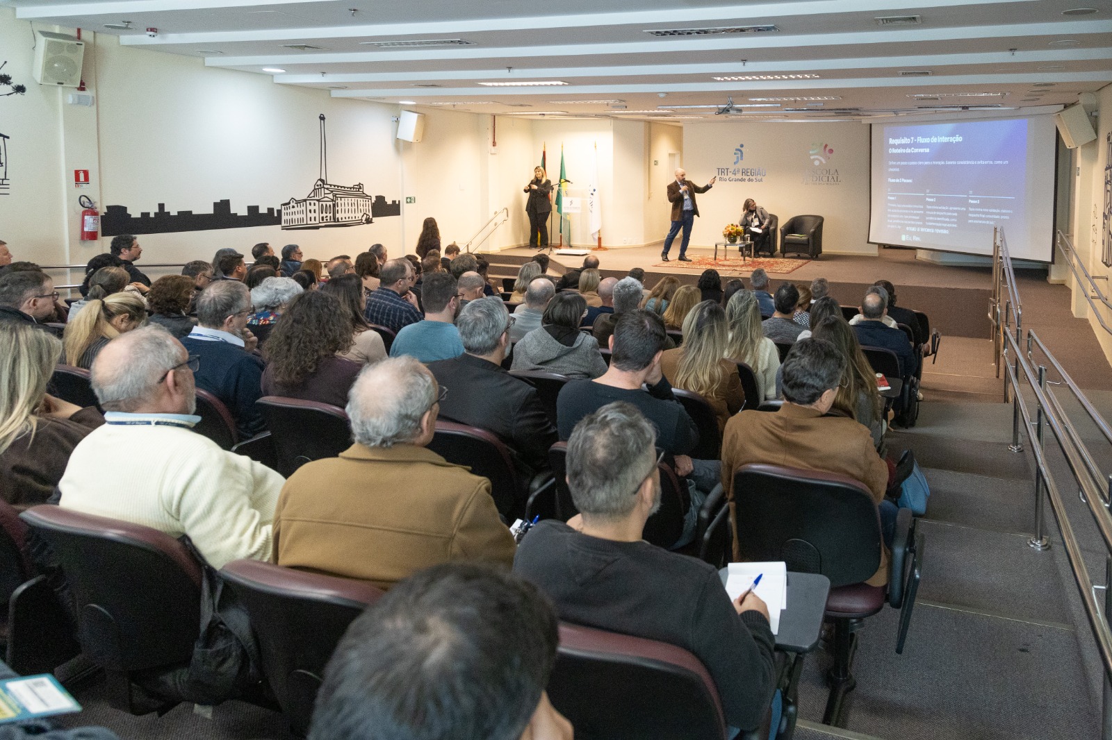 A foto mostra a palestra do servidor Rafael, com o público na frente.