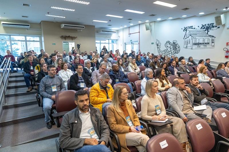 A fotografia mostra a plateia do evento, composta de diretores e diretoras de secretaria