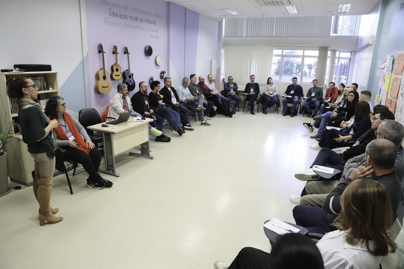 A fotografia mostra os diretores sentados em semicírculo, no 2º Encontro, realizado em 2025