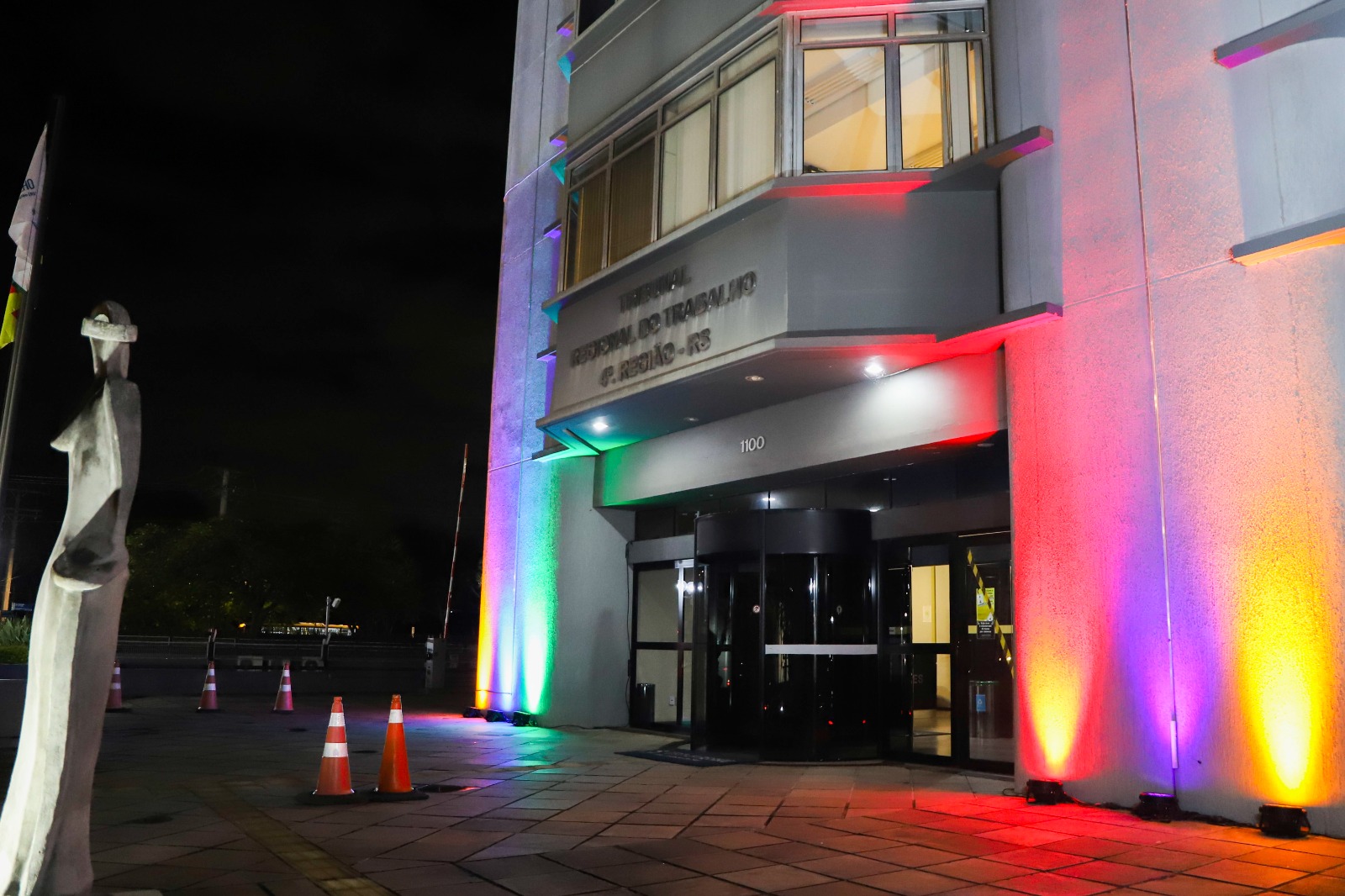 fachada do prédio-sede do Tribunal iluminada com as cores vermelho, roxo, verde e amarelo.