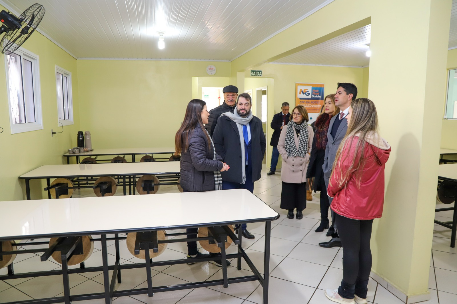 A foto mostra comitiva conhecendo refeitório.