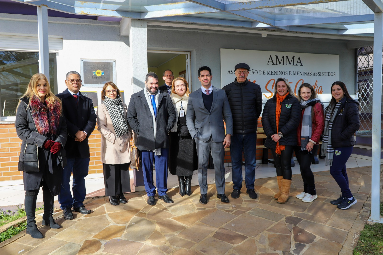 A foto mostra pessoas posando para foto na Amma