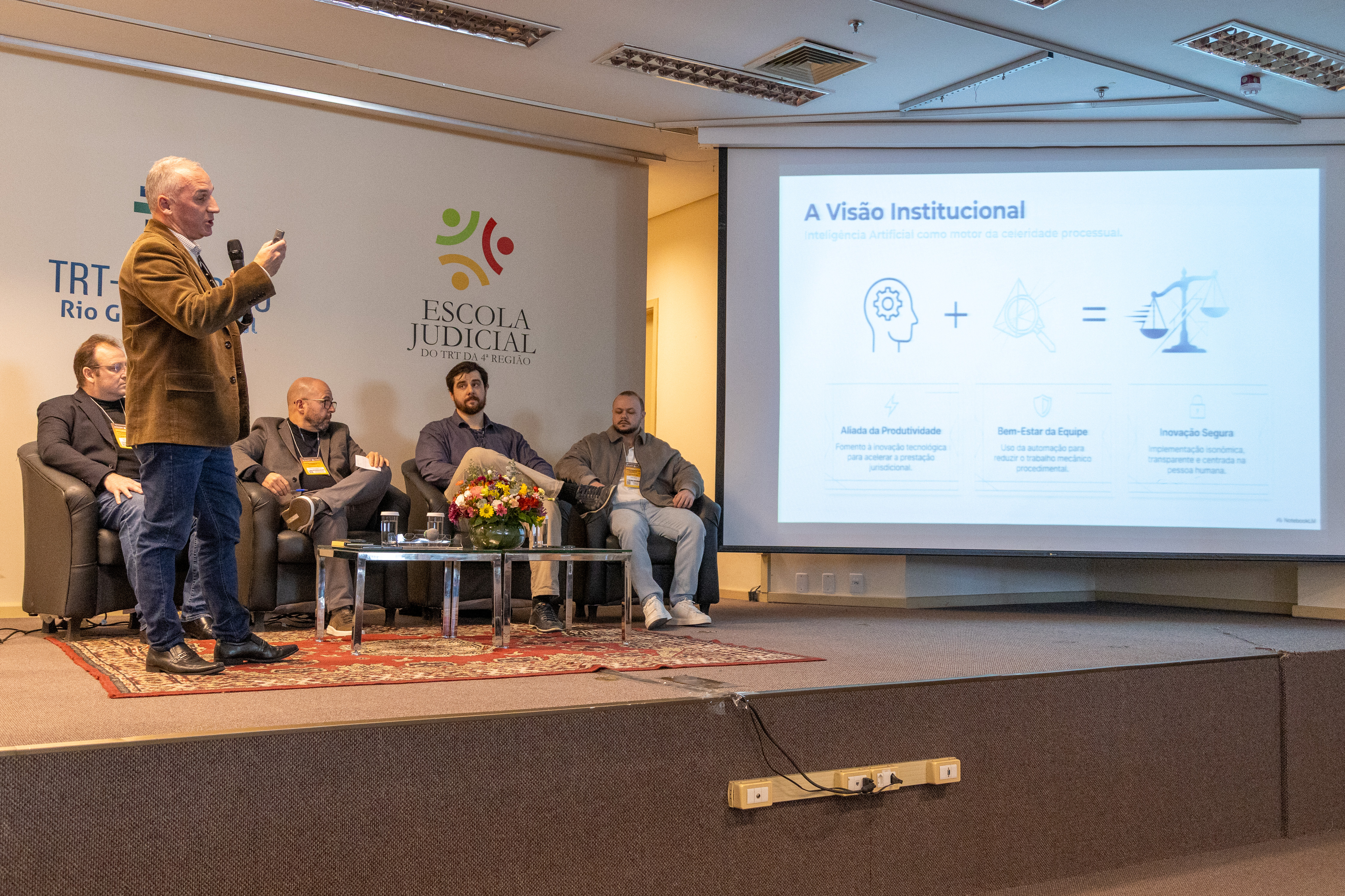 Servidor apresentando painel com outros servidores ao lado no palco.
