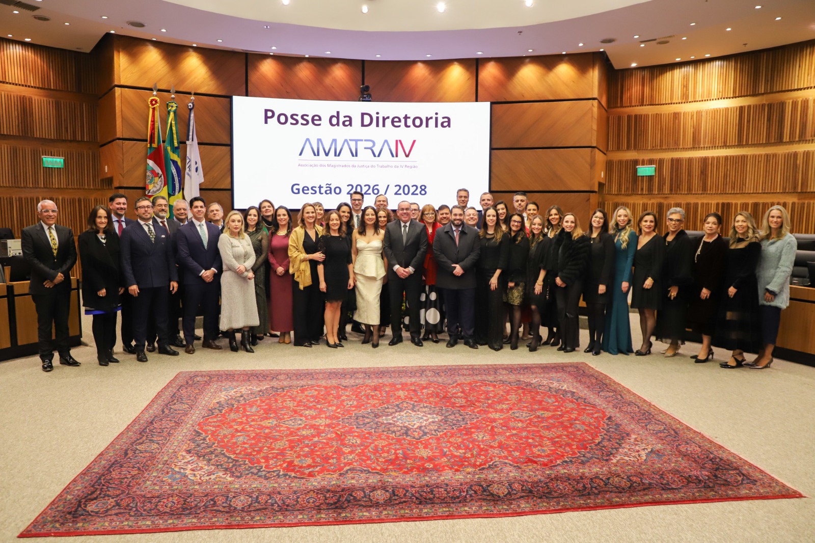 A foto mostra várias pessoas posando para foto no plenário do TRT