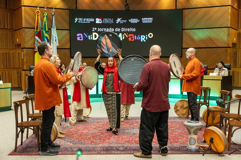 A fotografia mostra a apresentação "Sons do Oriente", com músicos tocando tambores persas em círculo.