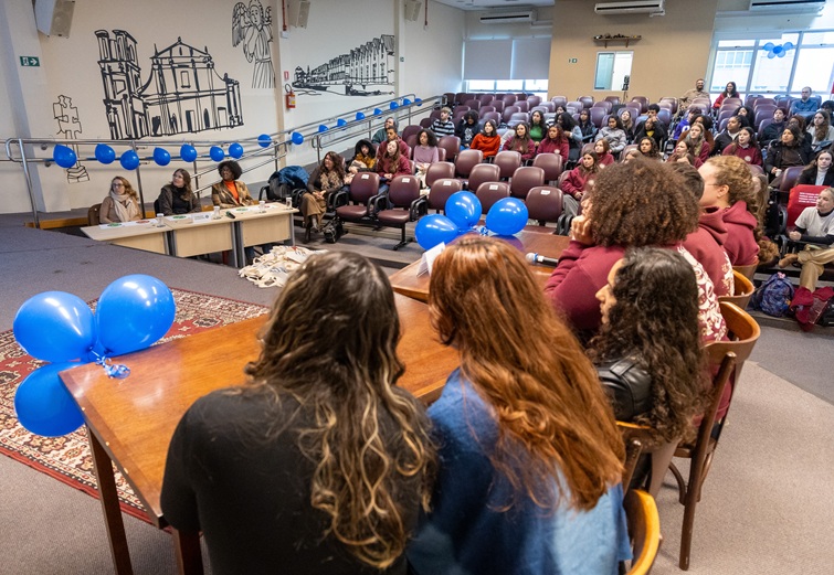 A fotografia mostra as equipes sentadas e o auditório.