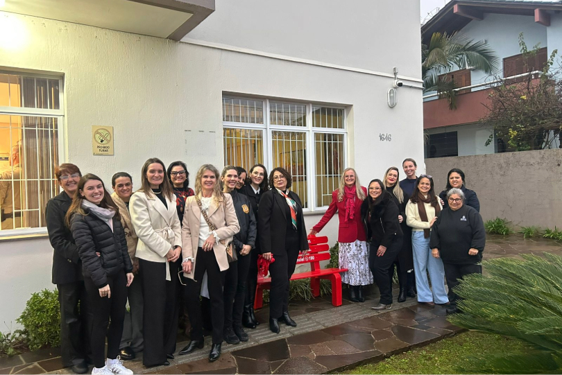 Grupo de mulheres em frente ao Banco Vermelho, símbolo de luta contra a violência de gênero.
