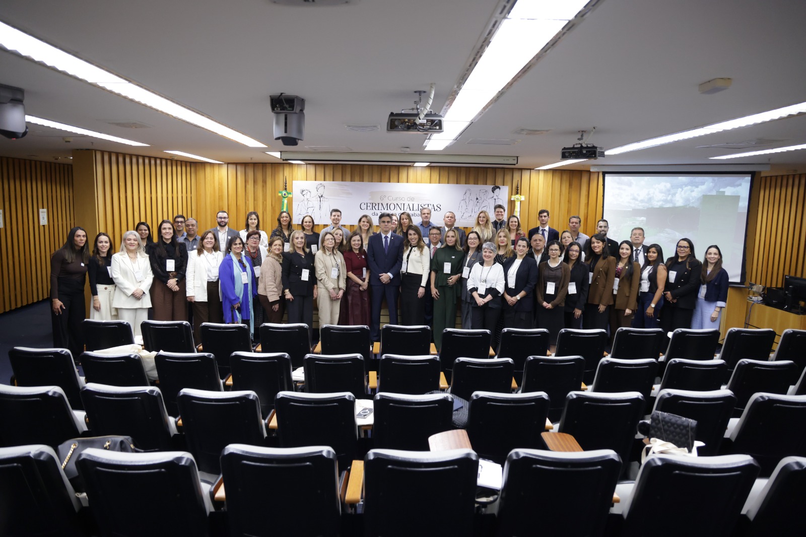 A foto mostra diversas pessoas lado a lado posando para foto.