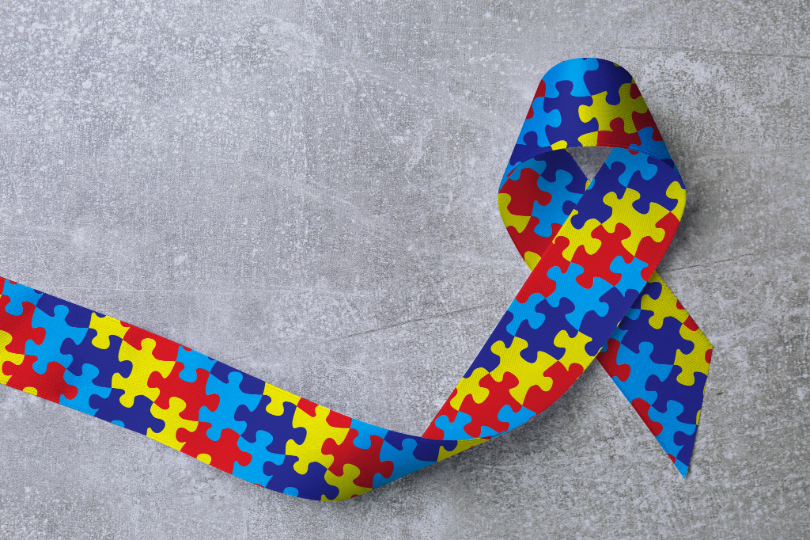 Fita colorida, que remete ao autismo, sobre fundo cinza