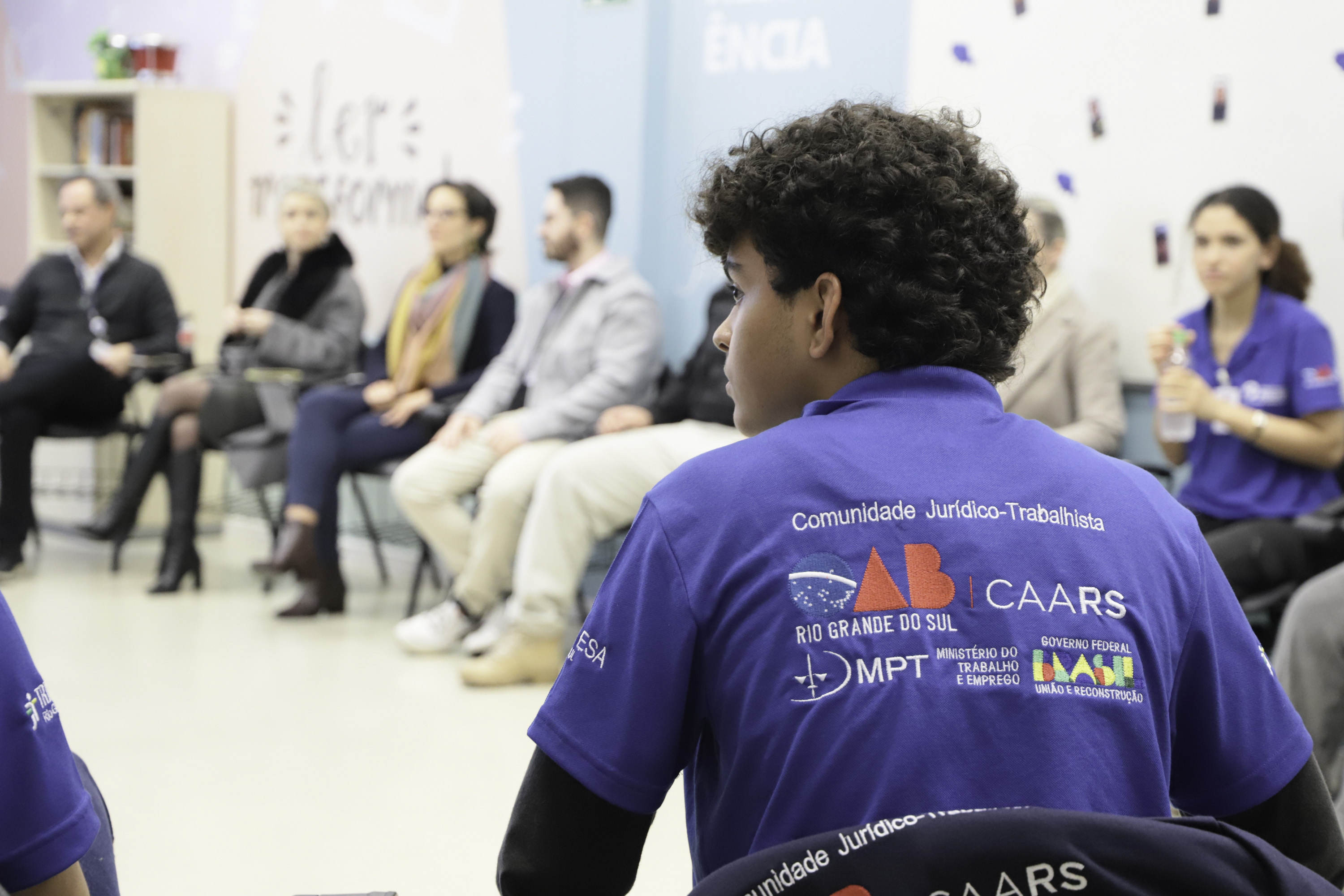 Aluno de costas em primeiro plano, com logos da parceiras do Pescar aparecendo em seu uniforme.