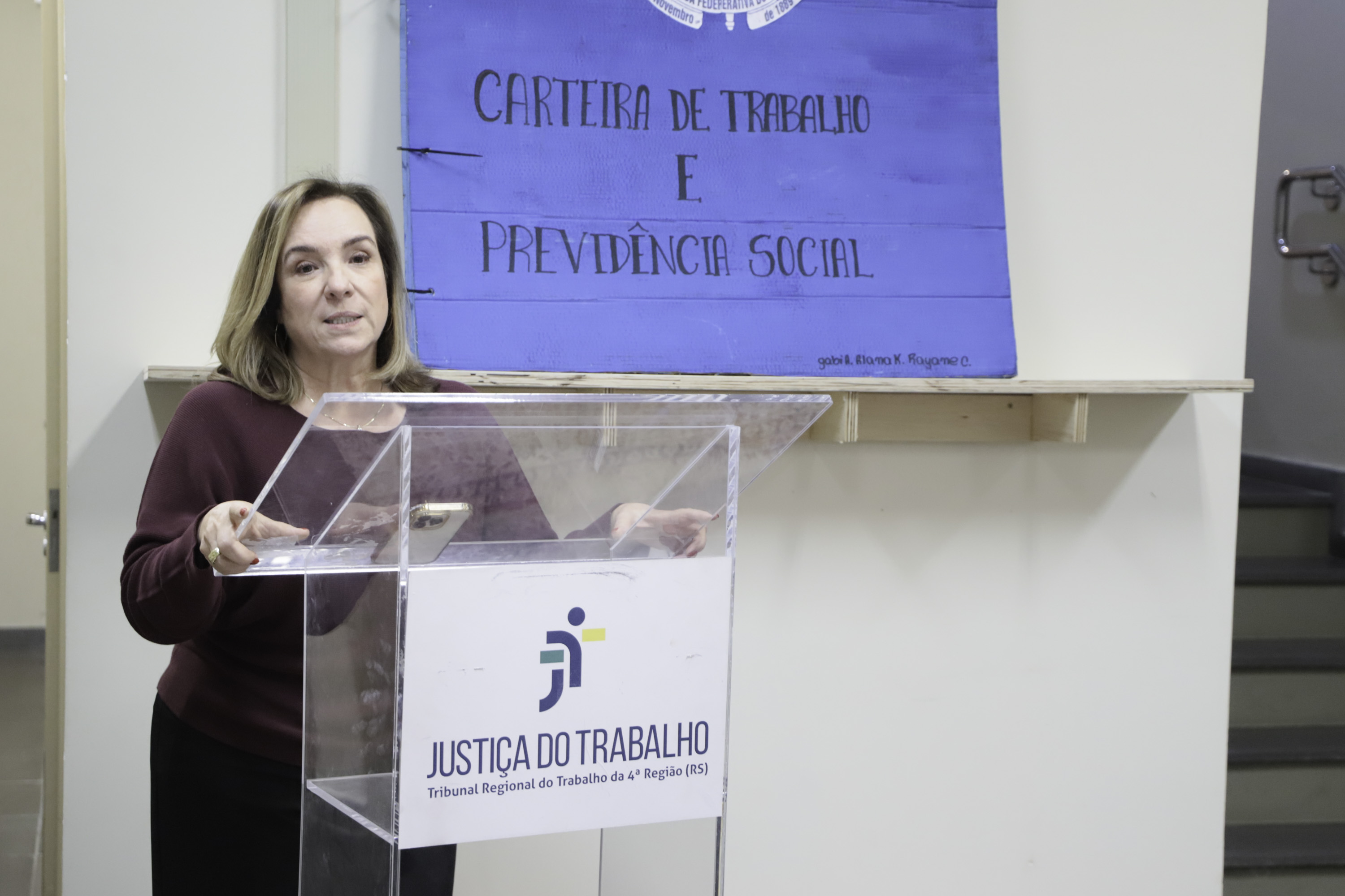 Maria Silvana fala no púlpito o com a obra ao fundo