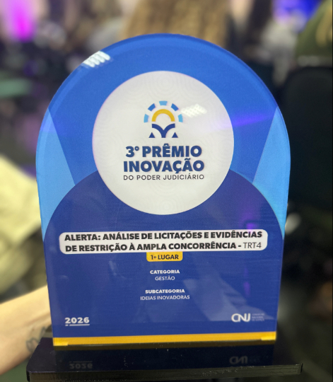 Troféu nas cores azul e branco, com a inscrição: Prêmio de Inovação do Poder Judiciário - 1º Lugar, Categoria Gestão, Subcategoria Ideias Inovadoras: Alerta - “Análise de Licitações e Evidências de Restrição à Ampla Concorrência - TRT4 - 2026.
