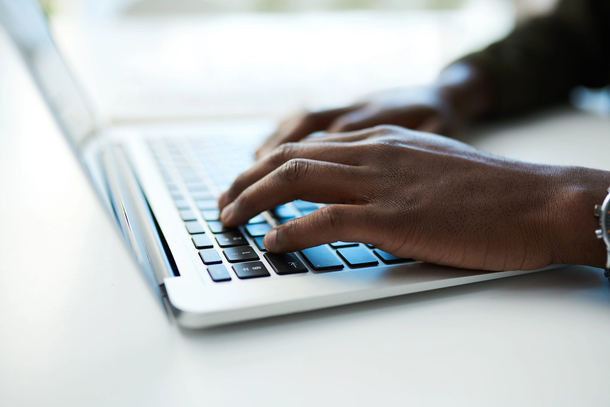 foto de um homem negro digitando em um laptop