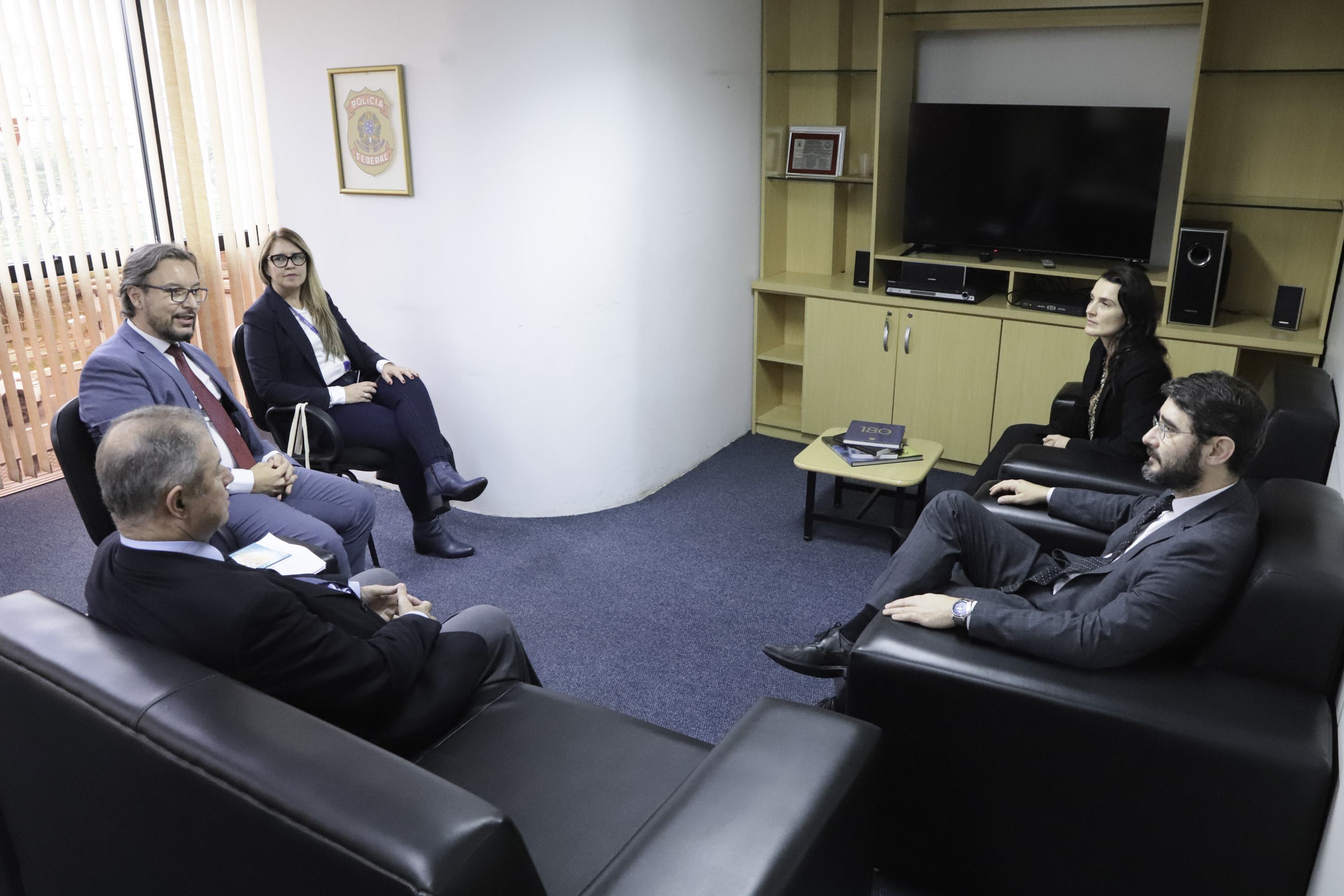 participantes estão sentados em sofás conversando.