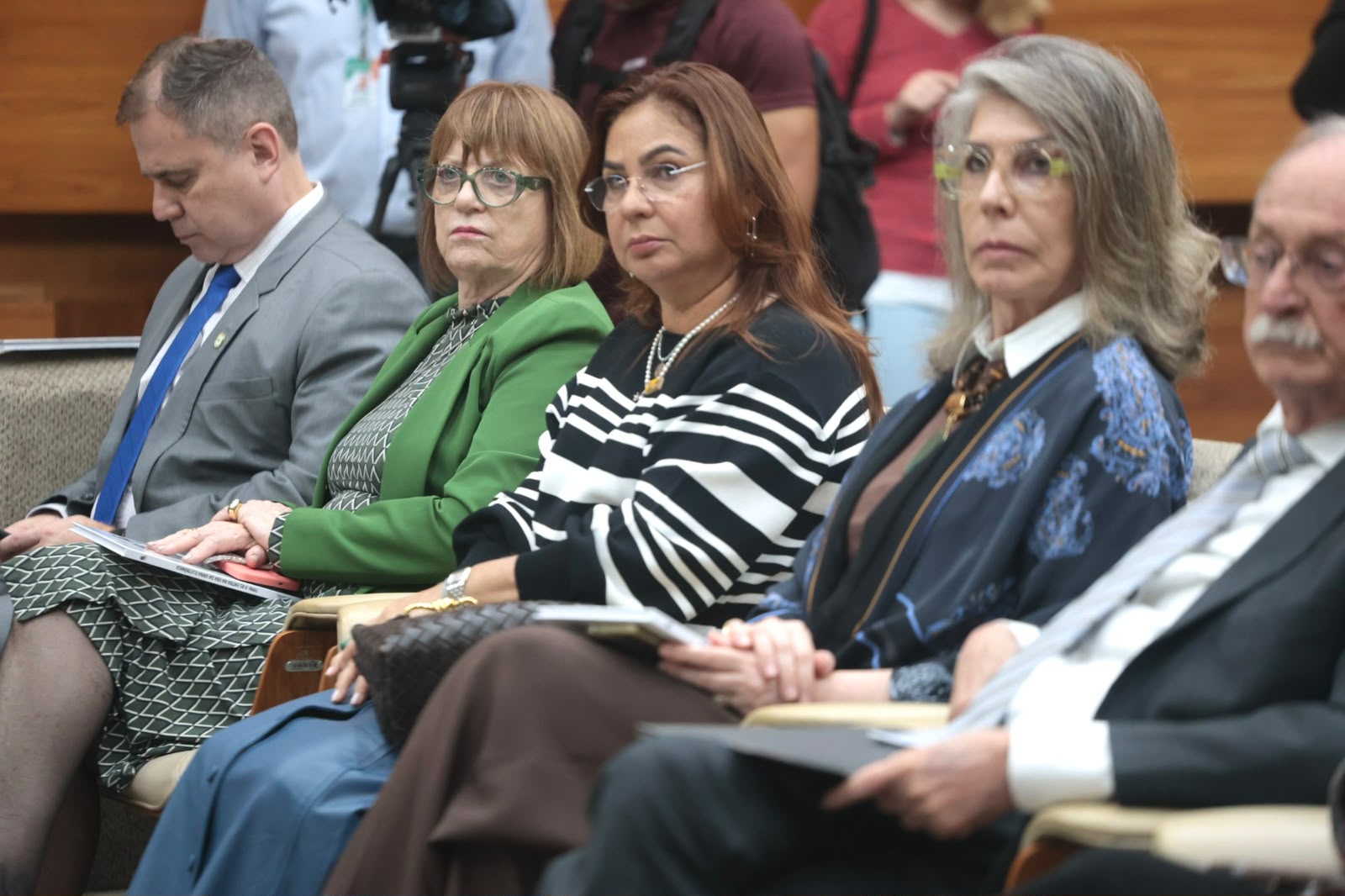 Maria Madalena Talesca está sentada no plateia assistindo à solenidade