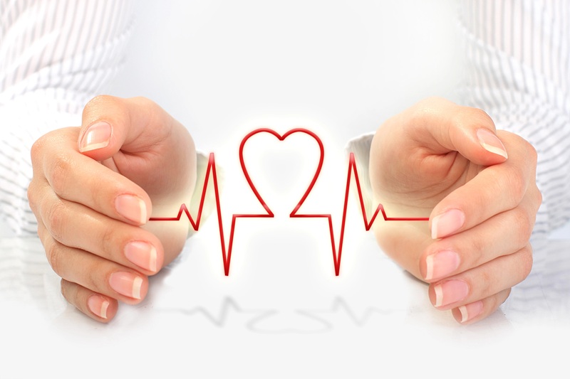 A fotografia mostra duas mãos em close, abertas, palmas voltadas uma para a outra, e entre elas uma linha vermelha em formato de coração lembrando um ecocardiograma.