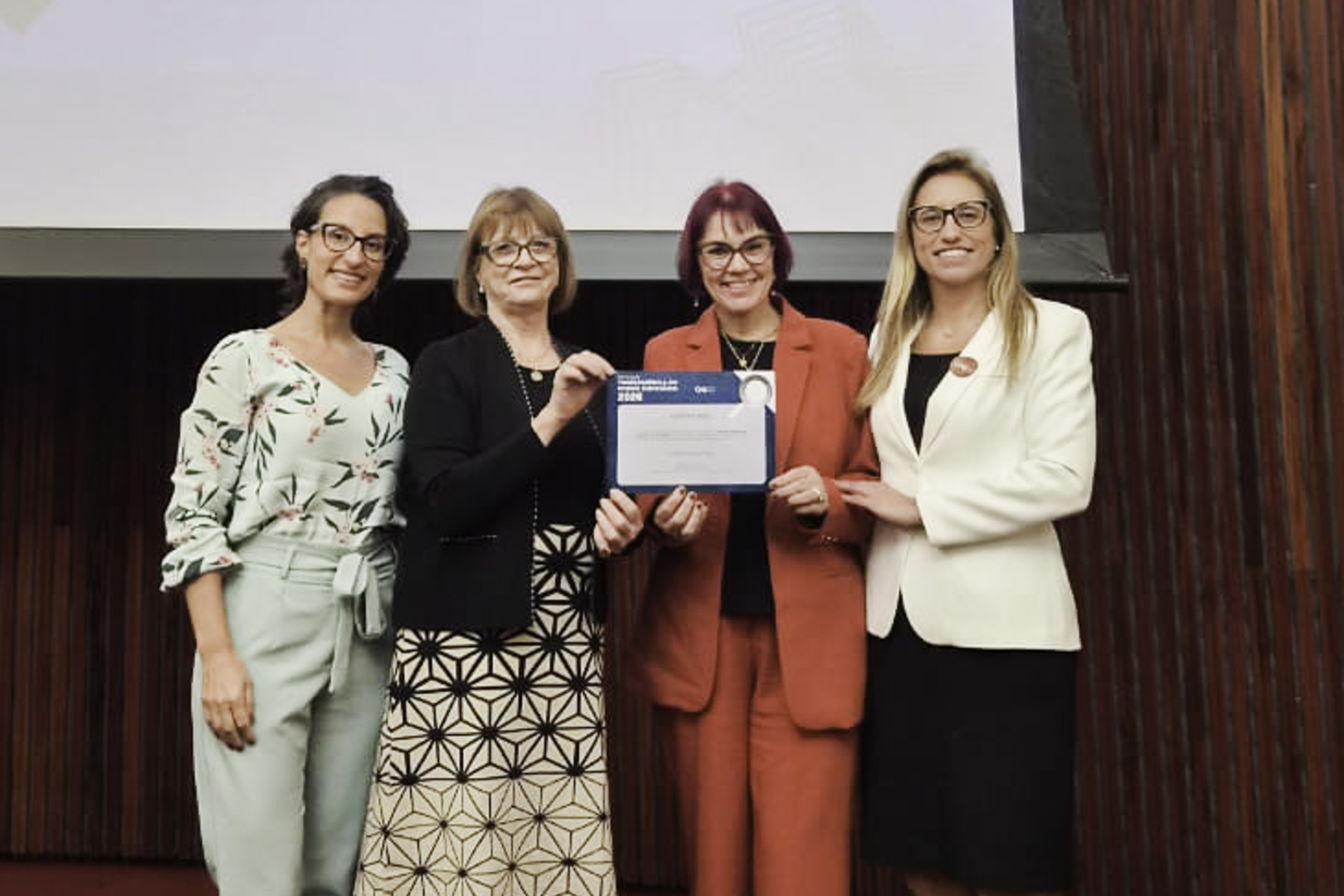 As quatro representantes do TRT-RS posam para a foto segurando o certificado da premiação
