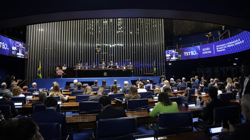 Foto em plano médio da sessão, mostrando parte da plateia e mesa oficial.