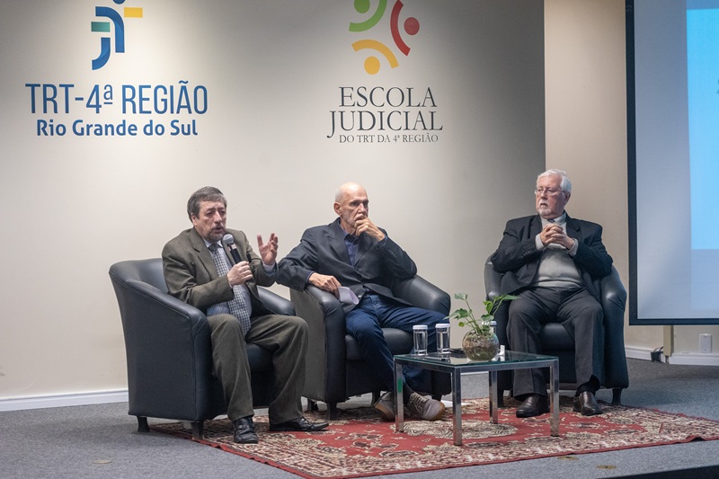 A fotografia mostra os palestrantes da primeira palestra, sentados, dialogando.