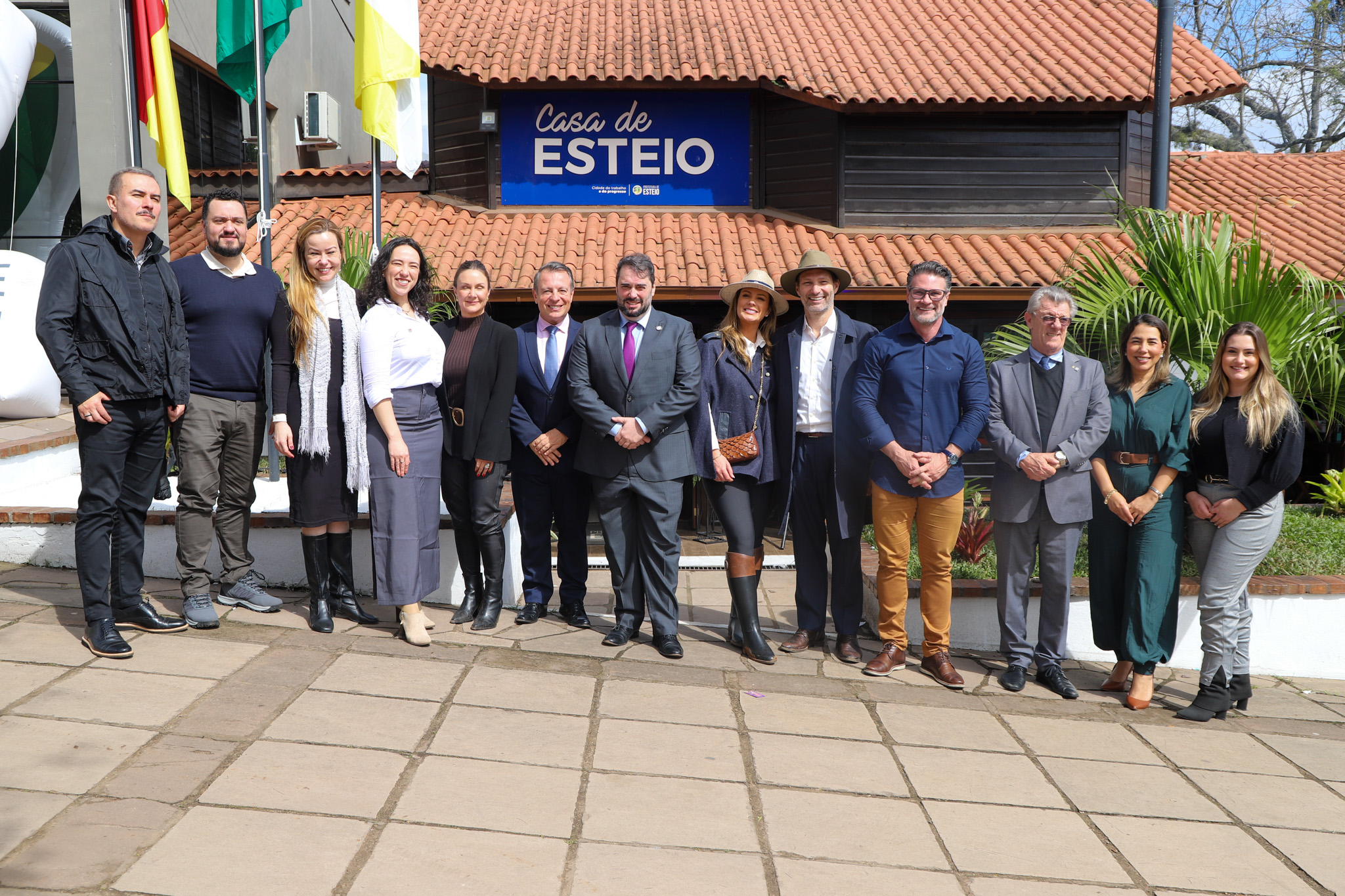 A foto mostra várias pessoas posando para foto lado a lado.