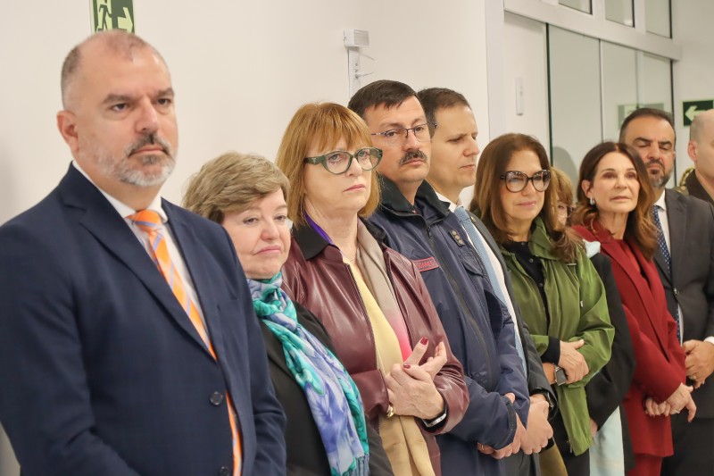Corregedora Regional do TRT-RS, desembargadora Maria Madalena Telesca de jaqueta na cor vinho e óculos verde. Na foto, ela está com outras pessoas.