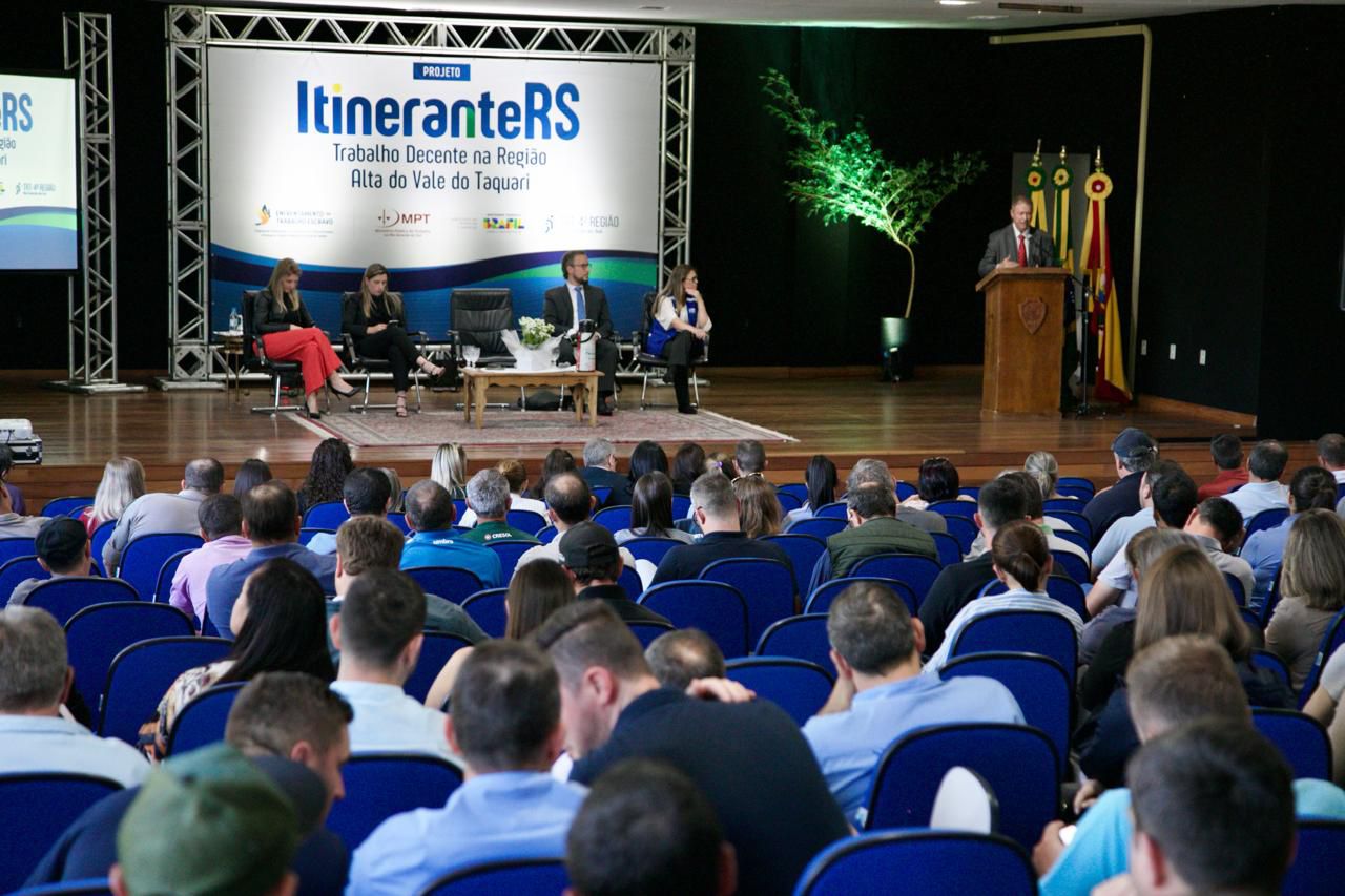 Foto em ângulo aberto, mostrando público e palco