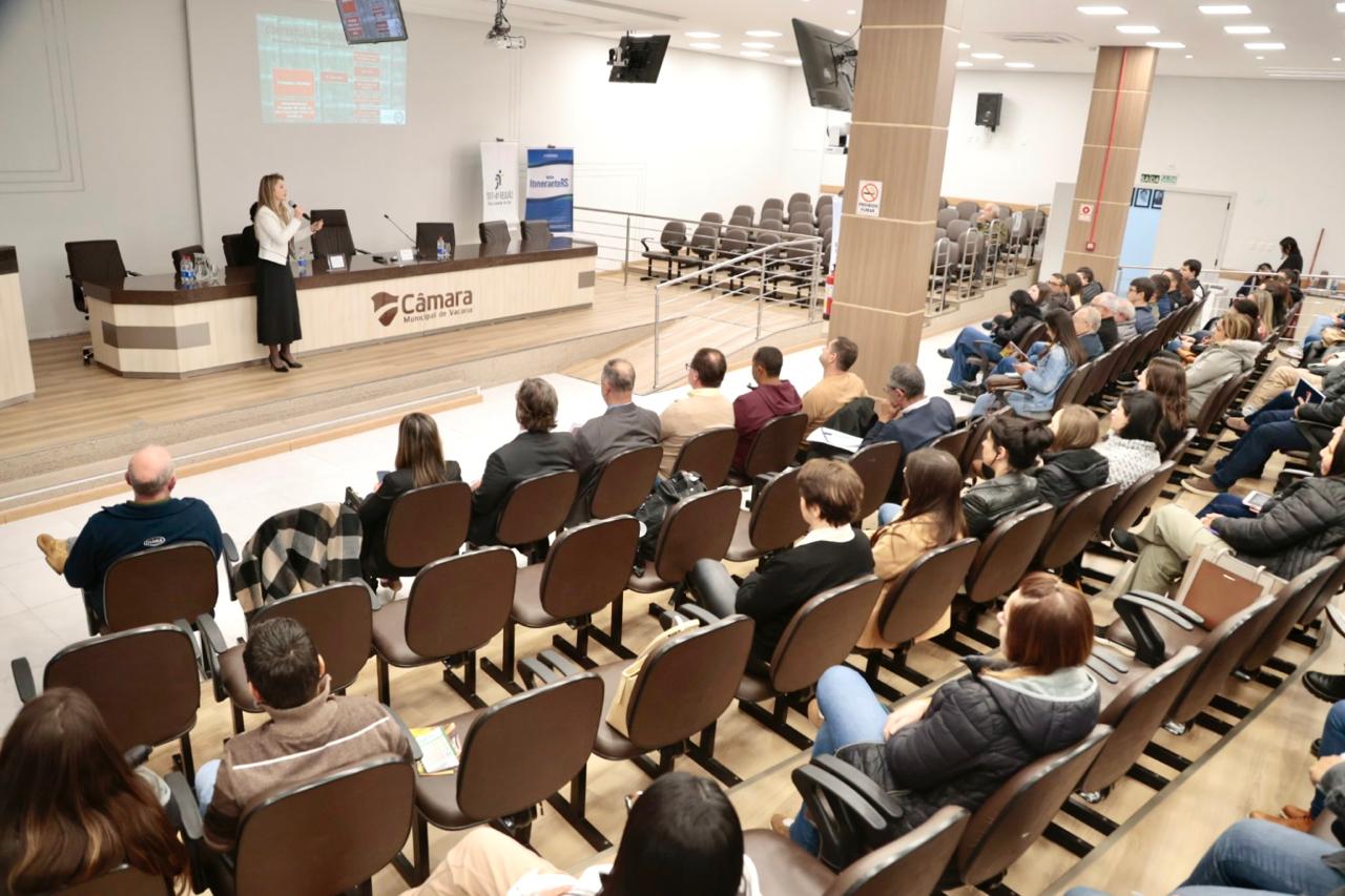 A imagem mostra a procuradora franciele palestrando, diante da plateia.