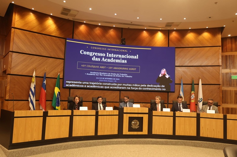A foto mostra os membros da mesa, no plenário, sentados. Atrás deles, há um telão com o banner do Congresso.