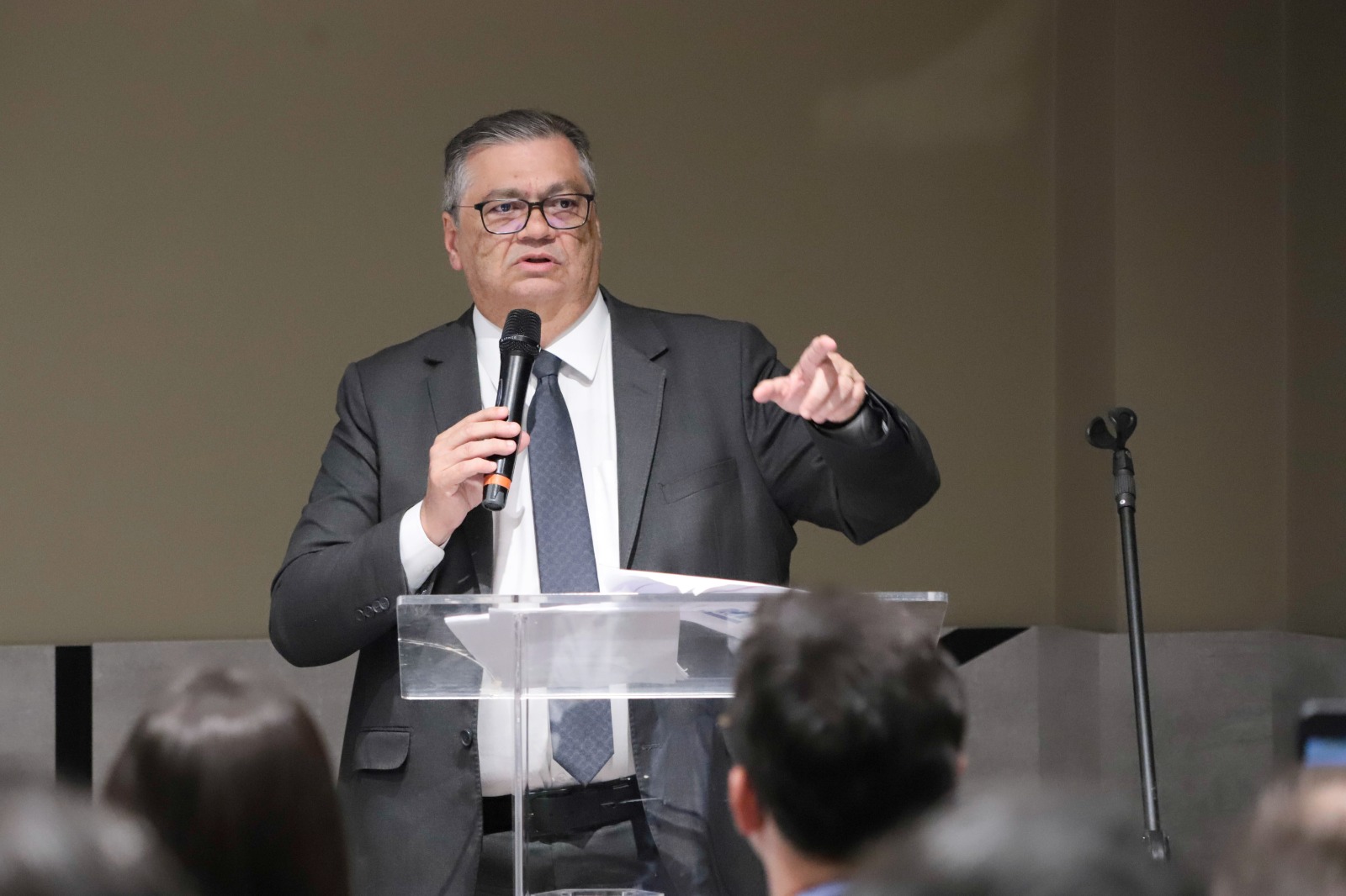 Flávio Dino fala de pé e gesticula no púlpito.