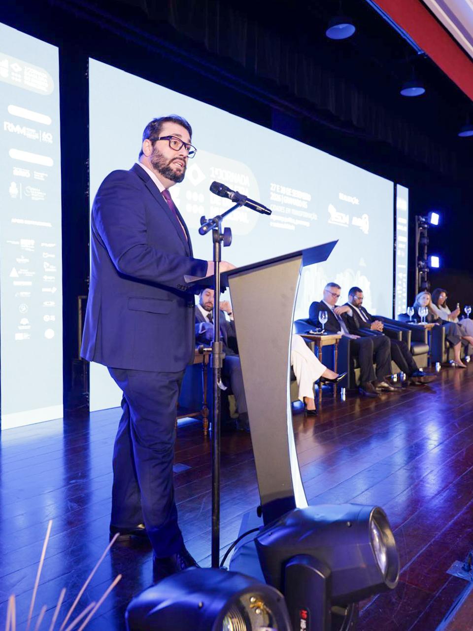 A foto mostra o presidente Alexandre discursando num púlpito.