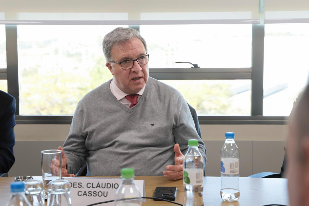 Cassou fala e gesticula olhando para a direita da imagem. 
