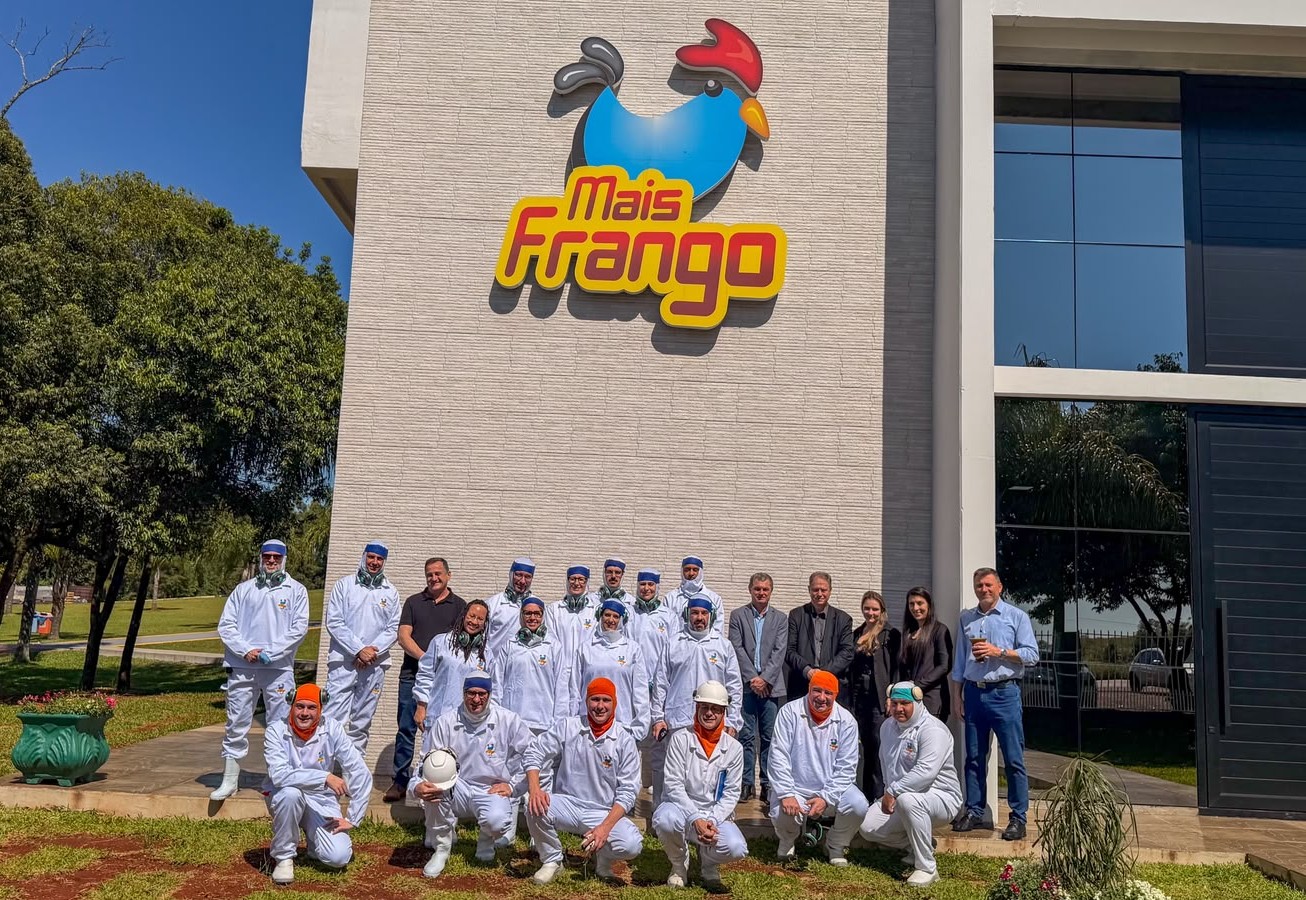 A foto mostra a comitiva do TRT junto com equipe da empresa Mais Frango em frente às instalações da empresa, todos posando, lado a lado.