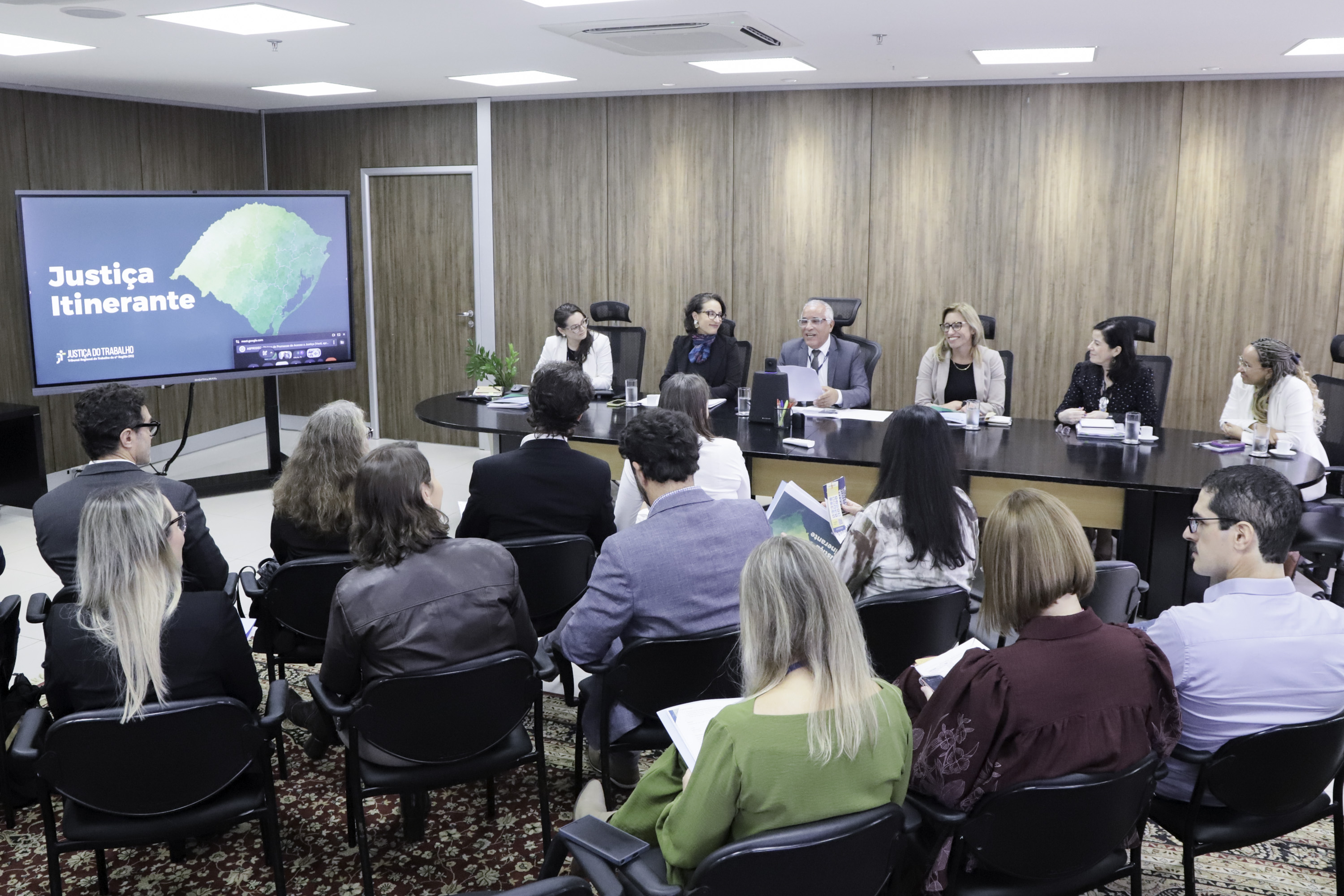 Público de costas no primeiro plano e mesa oficial ao fundo