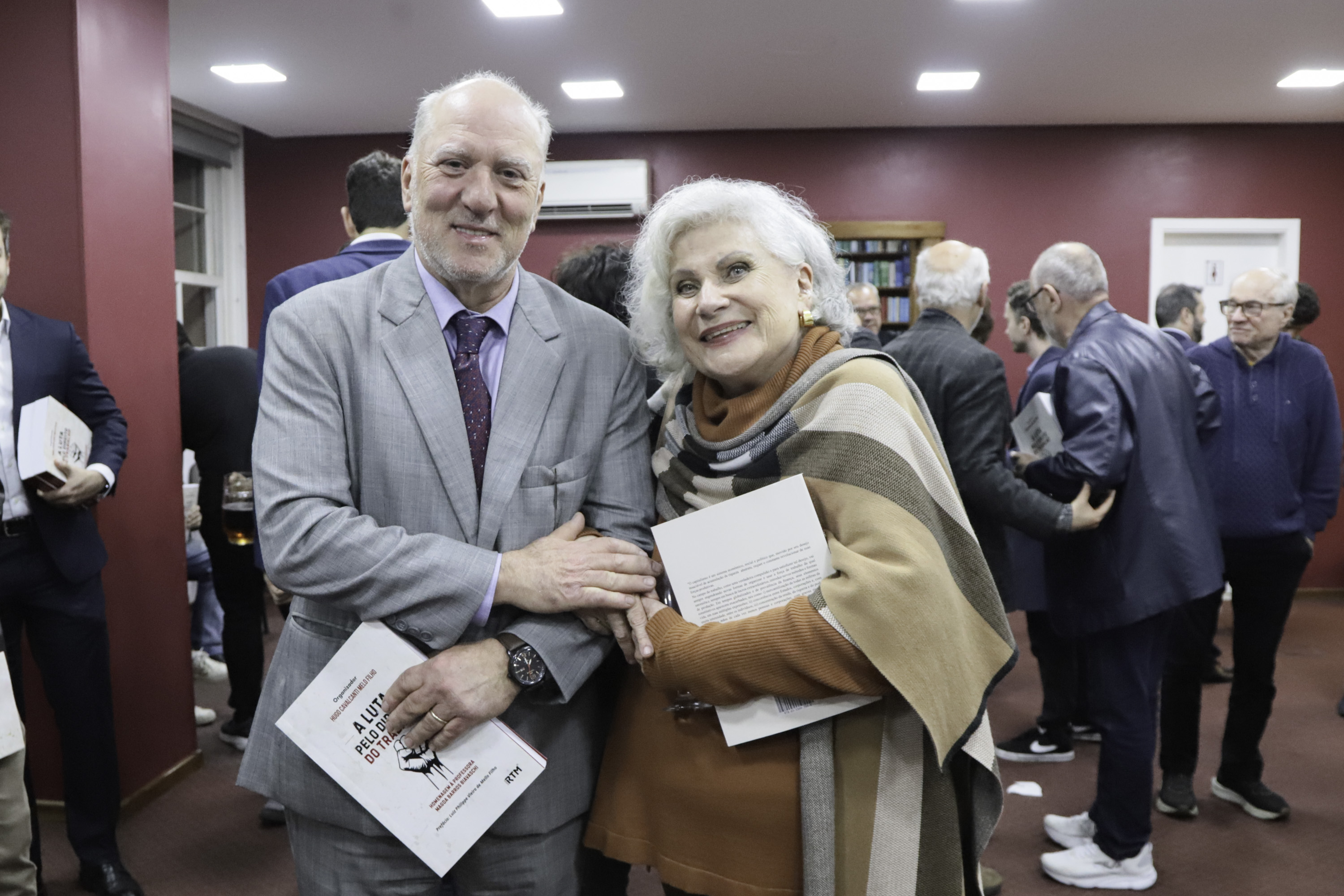 Martins Costa e Carmen Camino sorriem, atrás aparece o público presente.