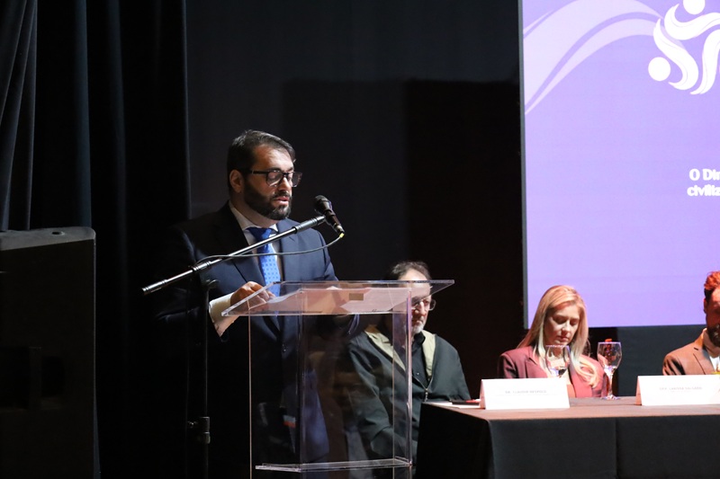 A foto mostra o presidente Alexandre discursando em um púlpito.
