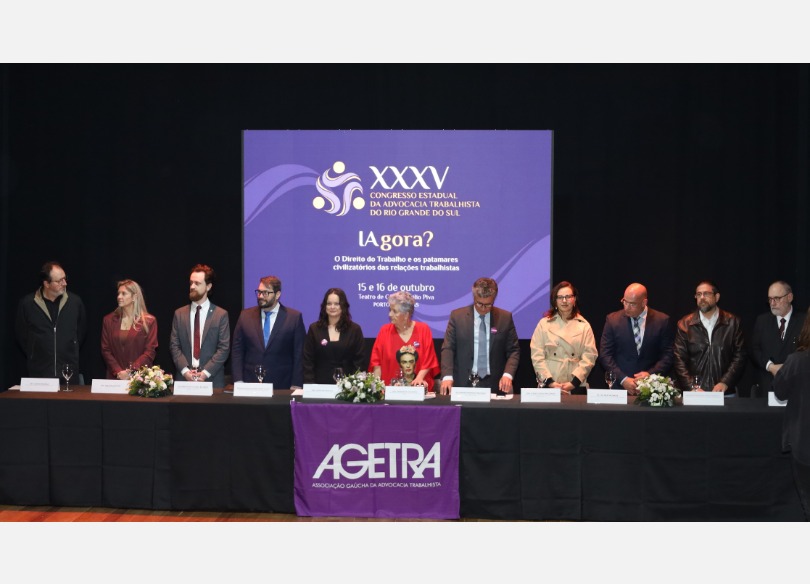 A foto mostra a mesa de abertura do evento, os participantes em pé.