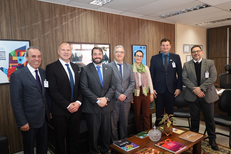 A fotografia mostra todos os presentes na reunião em pé, posando lado a lado, no gabinete do presidente.