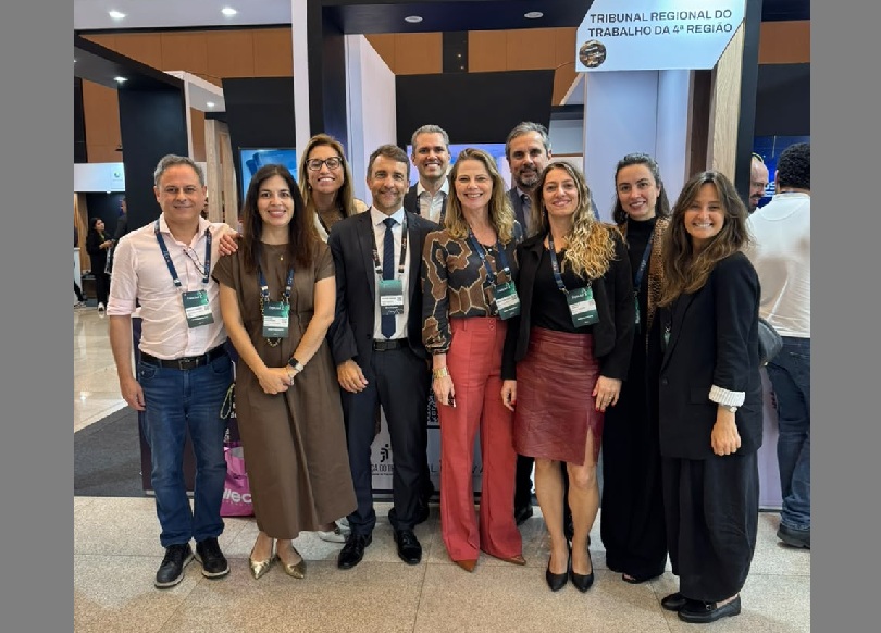 Equipe do TRT-RS presente da Expojud 2026 posa para a foto em frente ao estande do Tribunal.