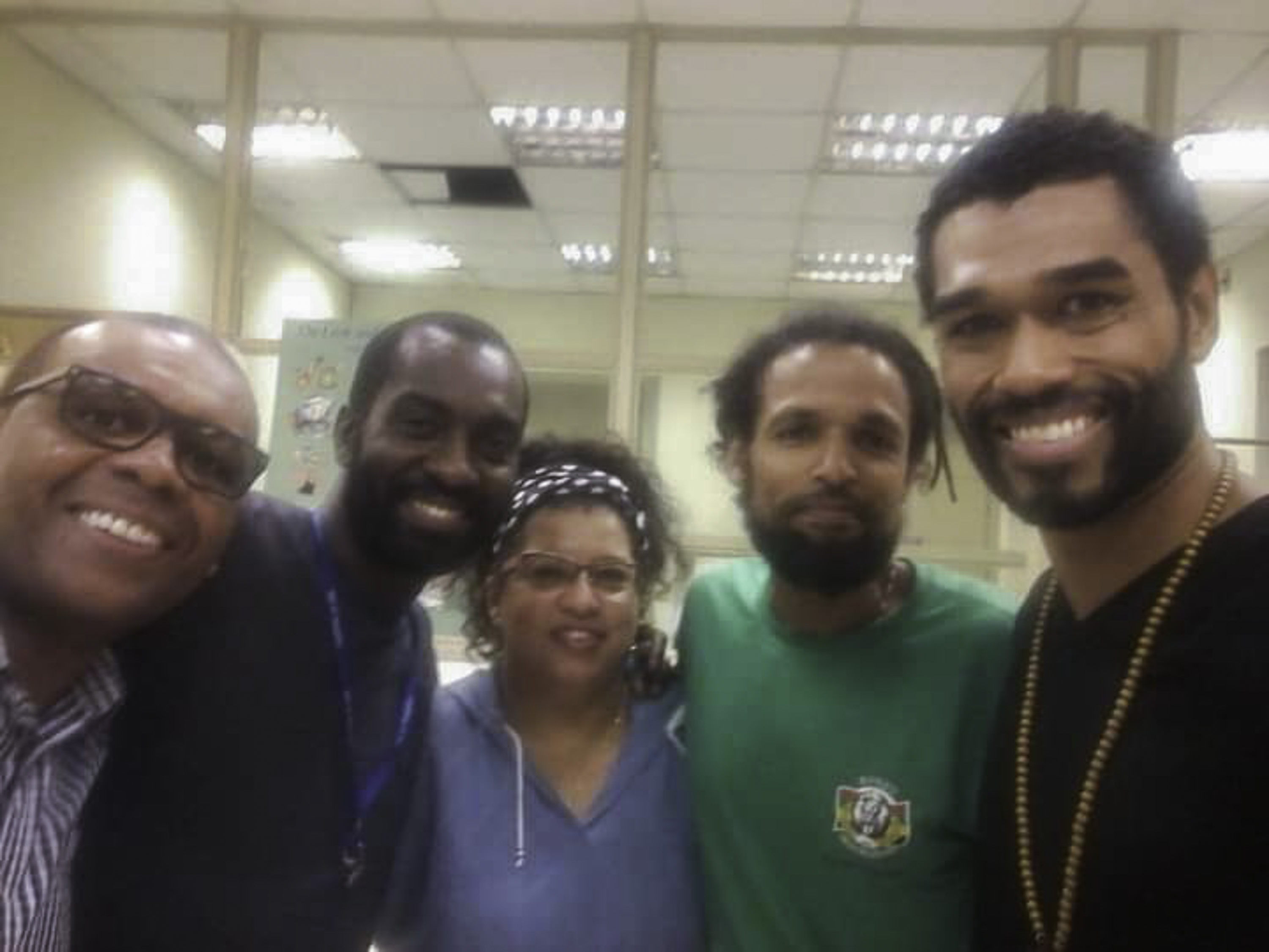 Cinco pessoas sorriem para a foto em uma selfie.