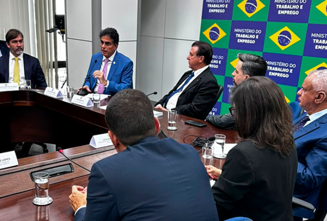 Foto do ministro Vieira de Mello Filho falando ao microfone durante coletiva de imprensa.