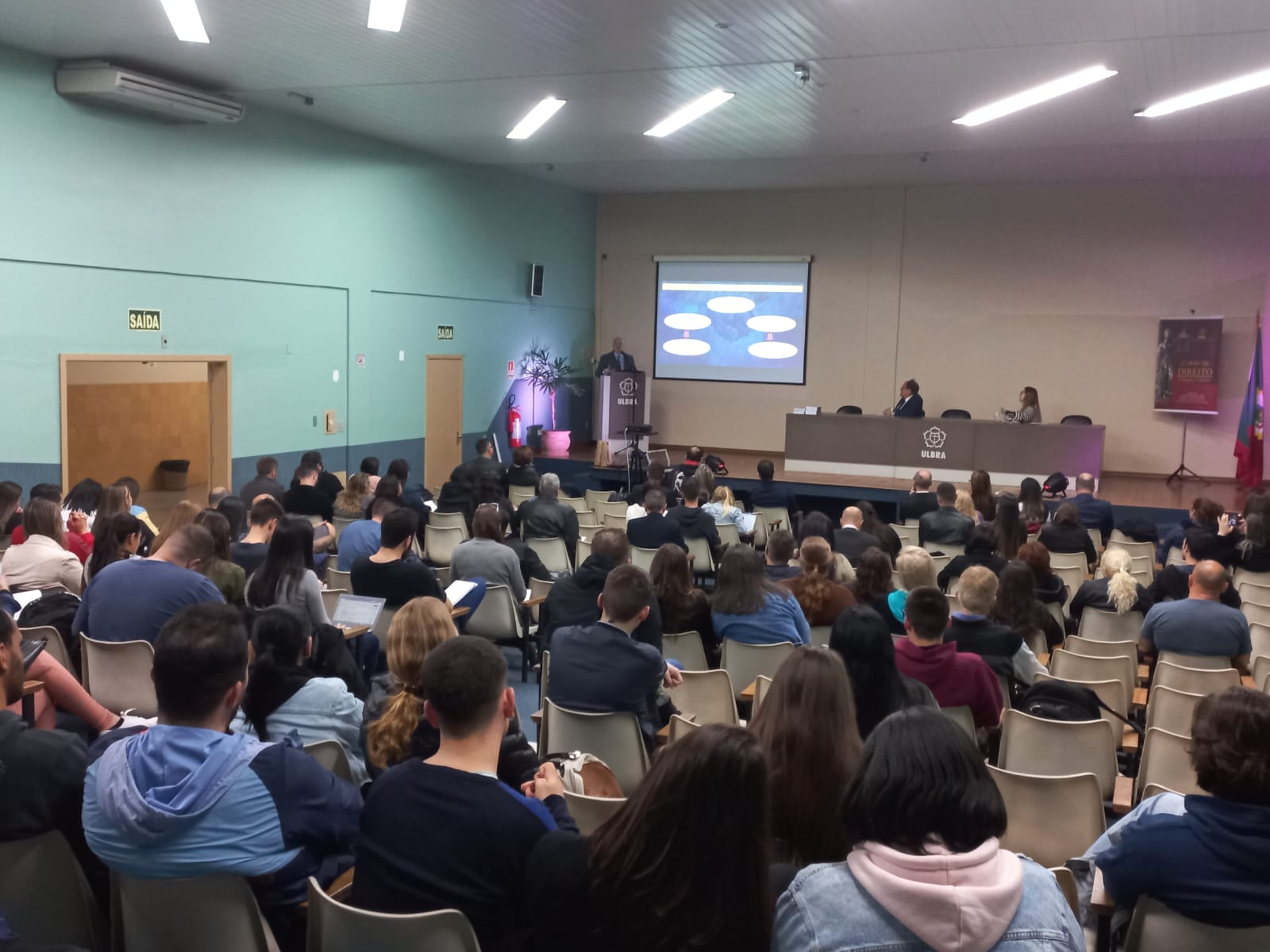 Foto em ângulo aberto, mostrando público e palco.