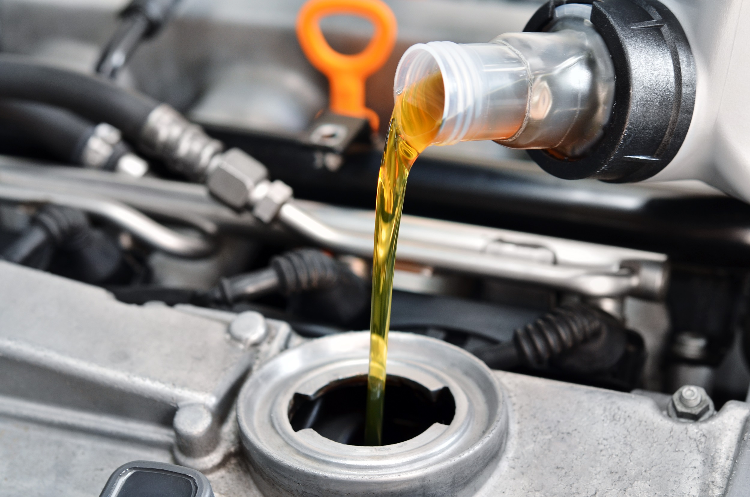 Imagem mostra tanque de carro sendo abastecido com óleo diesel. As peças do carro são da cor cinza e o óleo em cor amarela. 