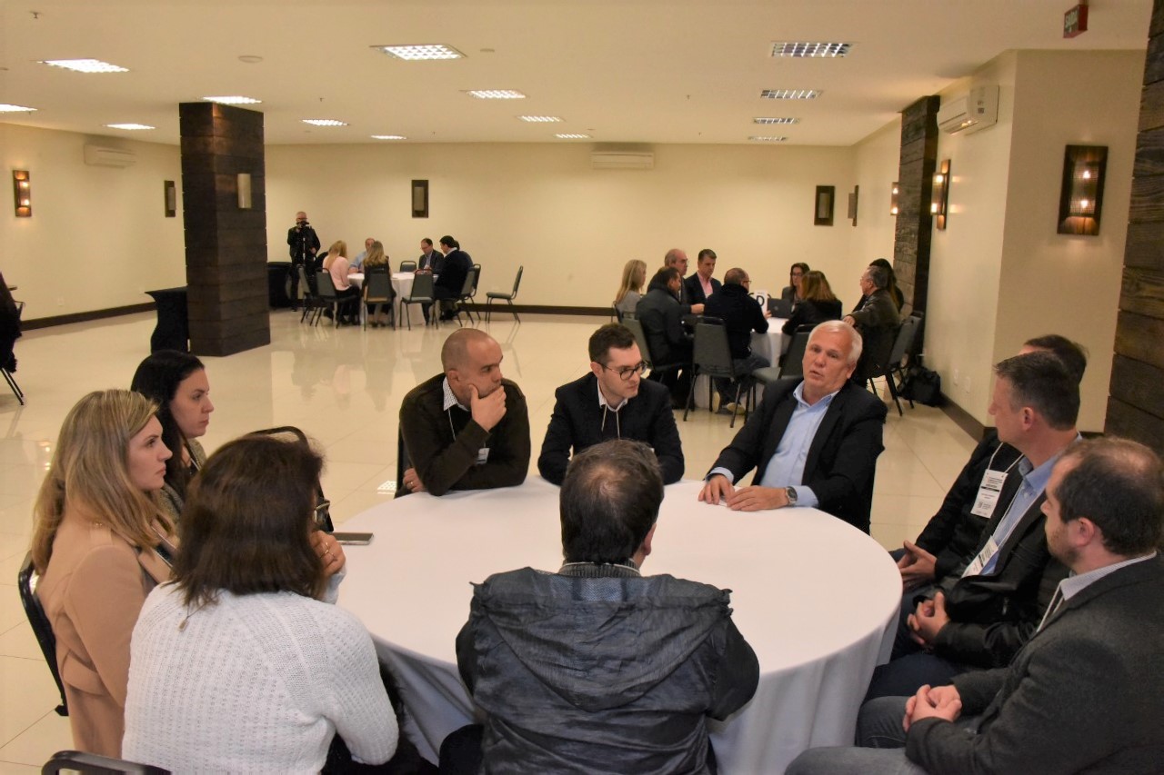 Foto de uma das salas, mostrando as mesas redondas e os magistrados debatendo