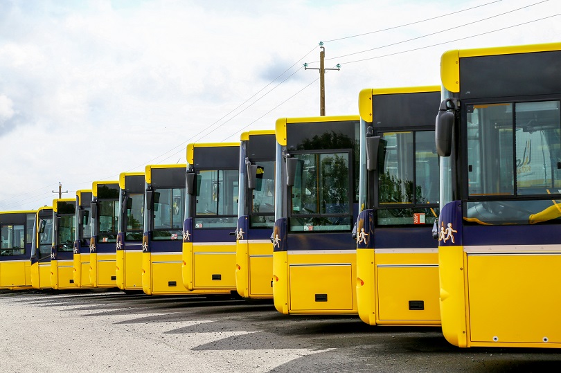 Foto ilustrativa em plano médio de uma fileira de ônibus estacionados lado a lado.