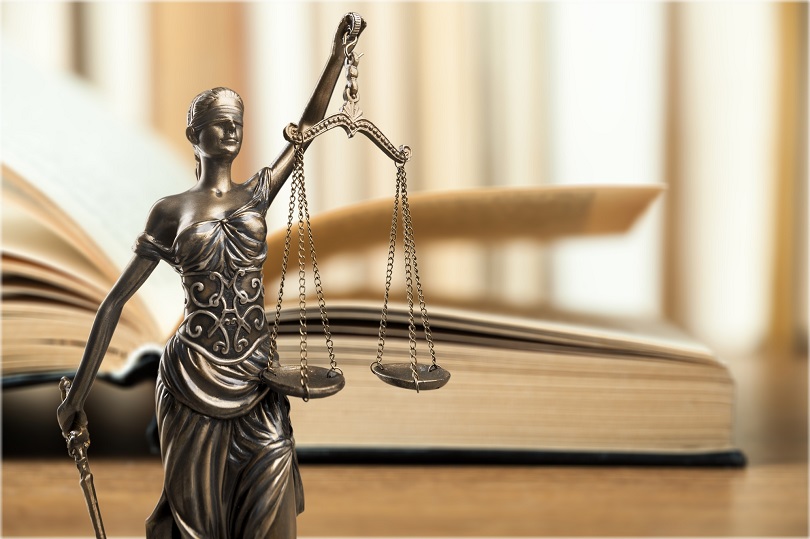 Foto ilustrativa em campo fechado de estátua em metal da deusa da Justiça.