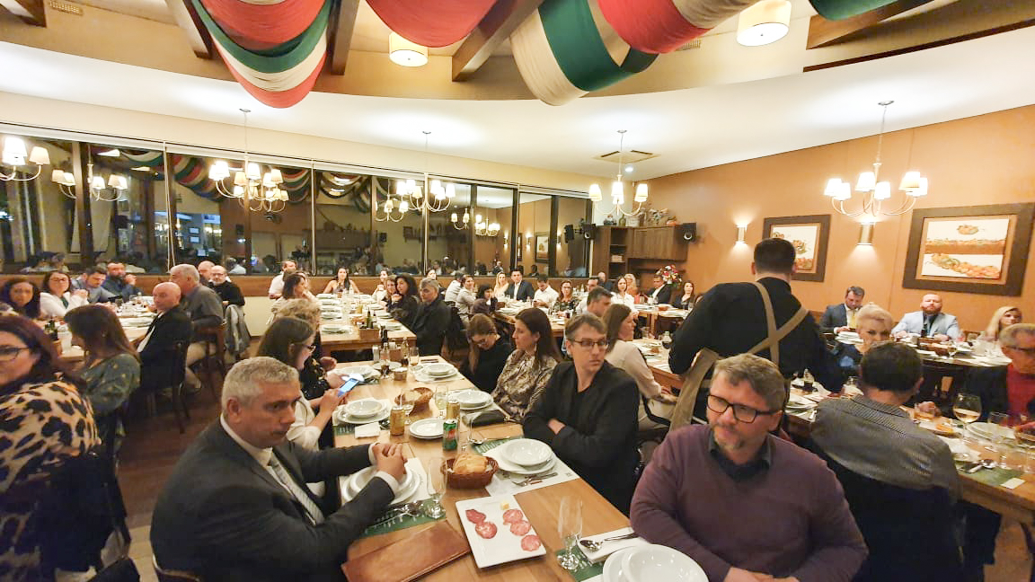 Foto geral do público na mesa do restaurante.
